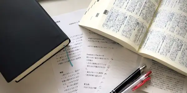 辞書と紙とペンの写真